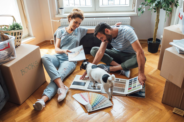 couple in new property living room looking at flooring material samples