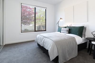 interior of modern master bedroom with dark grey carpet